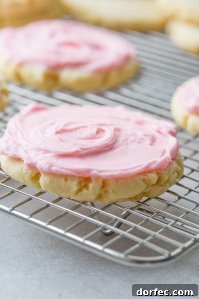 Copycat Swig Sugar Cookies and Signature Frosting 7 A close-up image of a single Swig Sugar Cookie with vibrant pink frosting, perfectly placed on a cooling rack, inviting a bite.