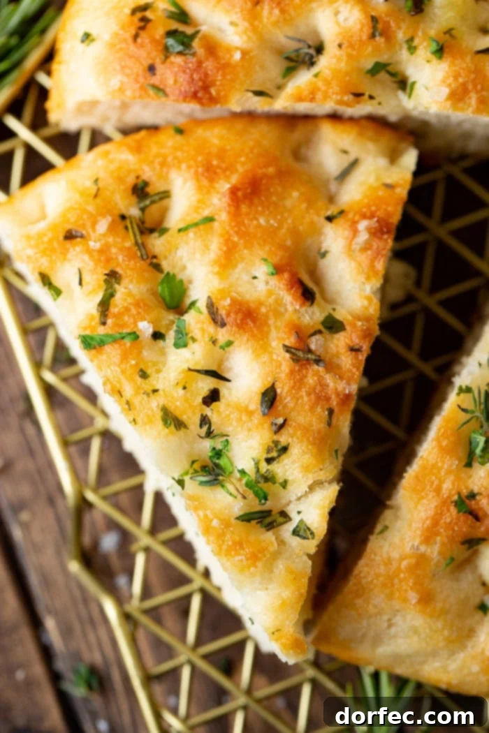 Effortless Herb Focaccia 4 A photo of a triangular piece of herbed focaccia bread.