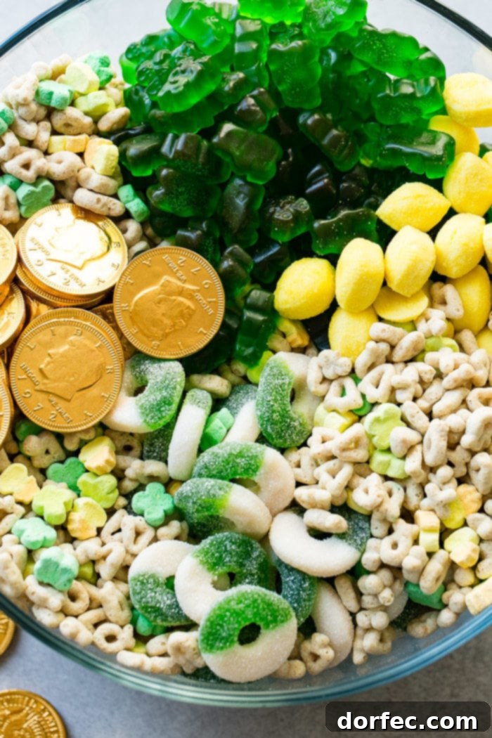 Instant Pot o' Gold Snack Mix 5 A detailed close-up shot of the irresistible St. Patrick's Day snack mix, capturing the intricate variety of textures and colors. The image beautifully highlights the individual green gummy candies, the gleaming golden chocolate coins, and the whimsical shapes of Lucky Charms, making it impossible to resist reaching in for a taste.