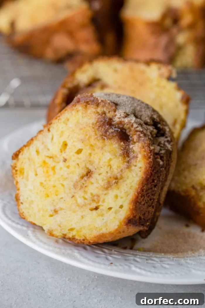 A close-up of a slice of brown sugar cinnamon bundt cake, highlighting the beautiful internal swirls of brown sugar and cinnamon, along with its sugary topping.