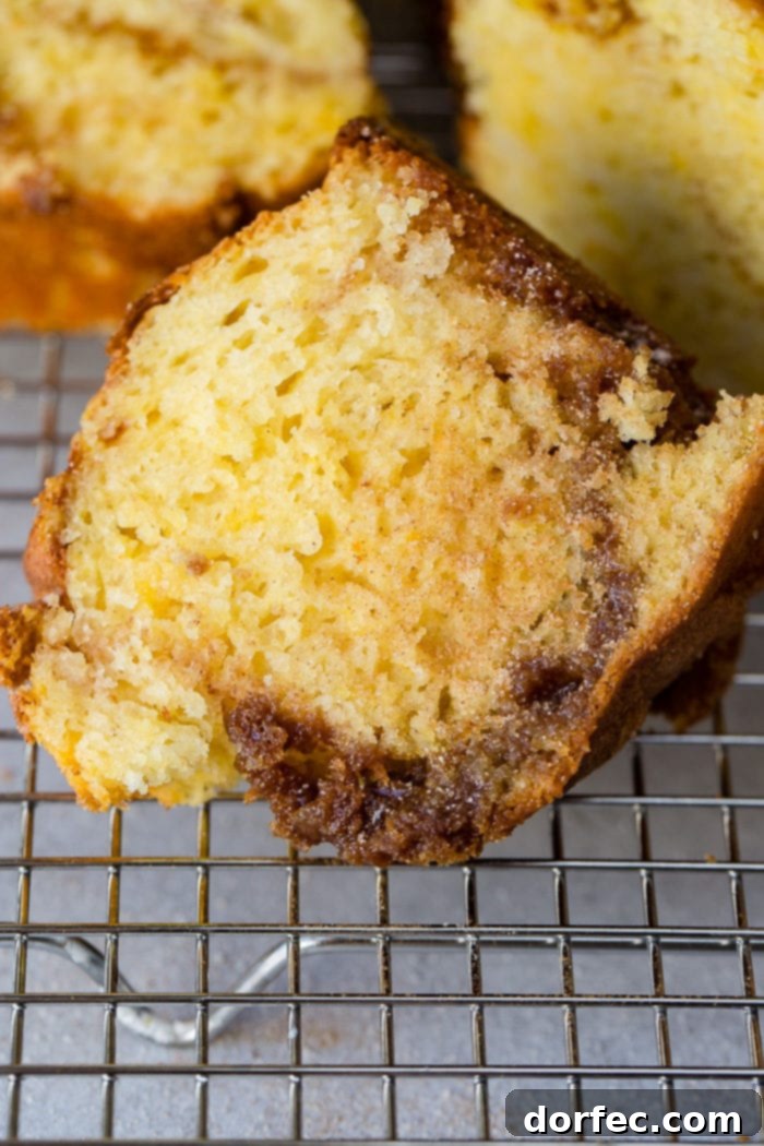 A warm brown sugar cinnamon bundt cake cooling on a wire rack, showcasing its unique shape and the subtle swirls within.