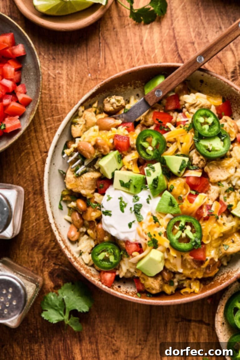 Flavor-Packed Instant Pot Cilantro Lime Chicken Burrito Bowls 2 A vibrant bowl of Instant Pot Cilantro Lime Chicken Burrito Bowl topped with melted cheese, a dollop of sour cream, and fresh sliced jalapeños.