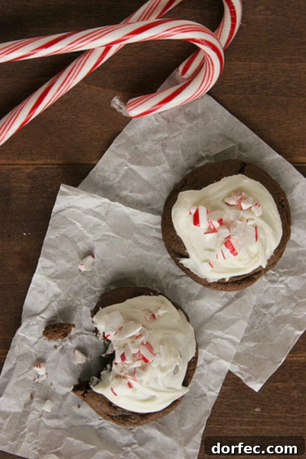 Delicious Chocolate Peppermint Cookies topped with white frosting and crushed candy canes, perfect for Christmas