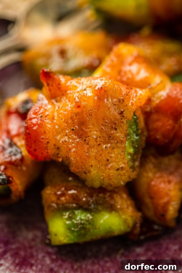 Crispy Bacon Avocado Wraps 3 Brown sugar bacon wrapped around a piece of avocado and baked until crispy is sitting on a pile of the bacon wrapped avocados