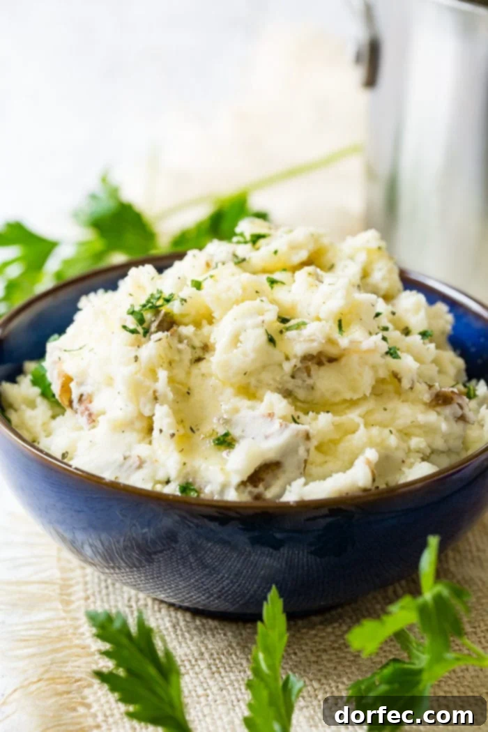 Crispy Smashed Steakhouse Potatoes 2 A photo of a vibrant blue serving bowl overflowing with chunky smashed potatoes, elegantly garnished with fresh chopped parsley.