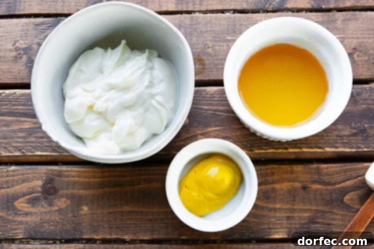 a photo of the ingredients for honey mustard dipping sauce in separate bowls including mayo, mustard and honey