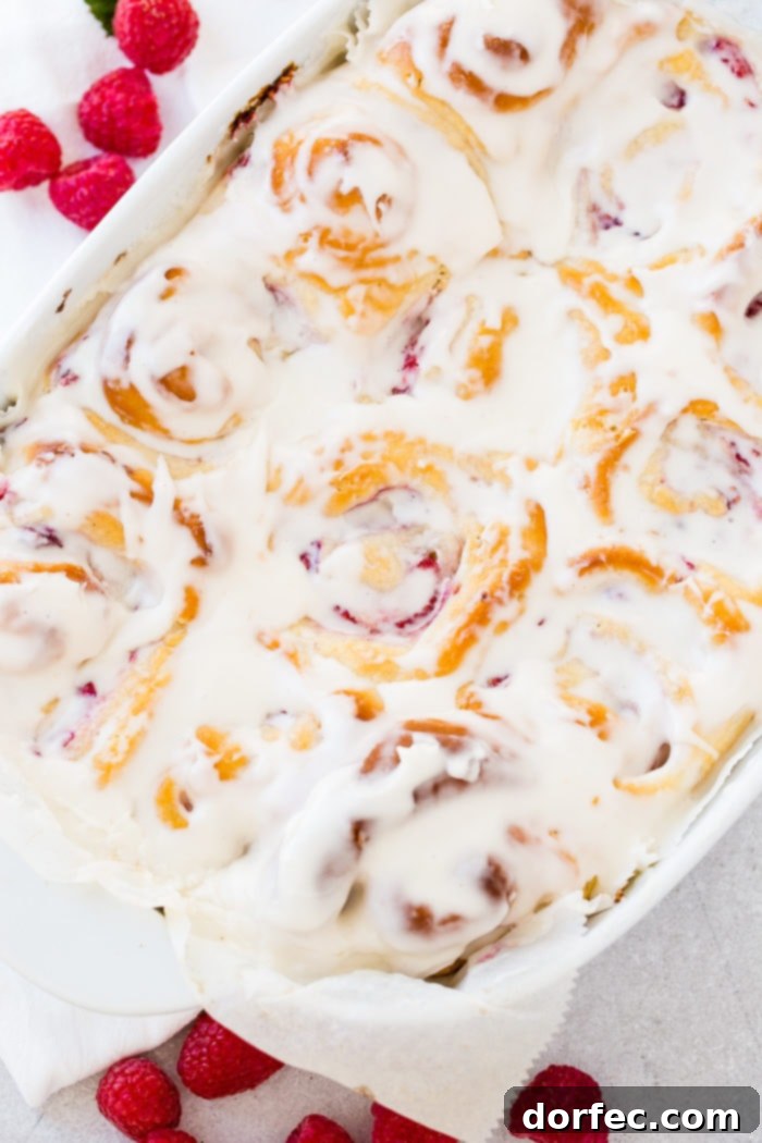 A photo of a pan of easy berry sweet rolls covered in frosting.