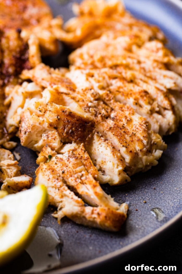 Effortless Traeger Smoked Chicken Breasts 5 A photo of sliced smoked chicken breasts and on a charcoal gray plate.