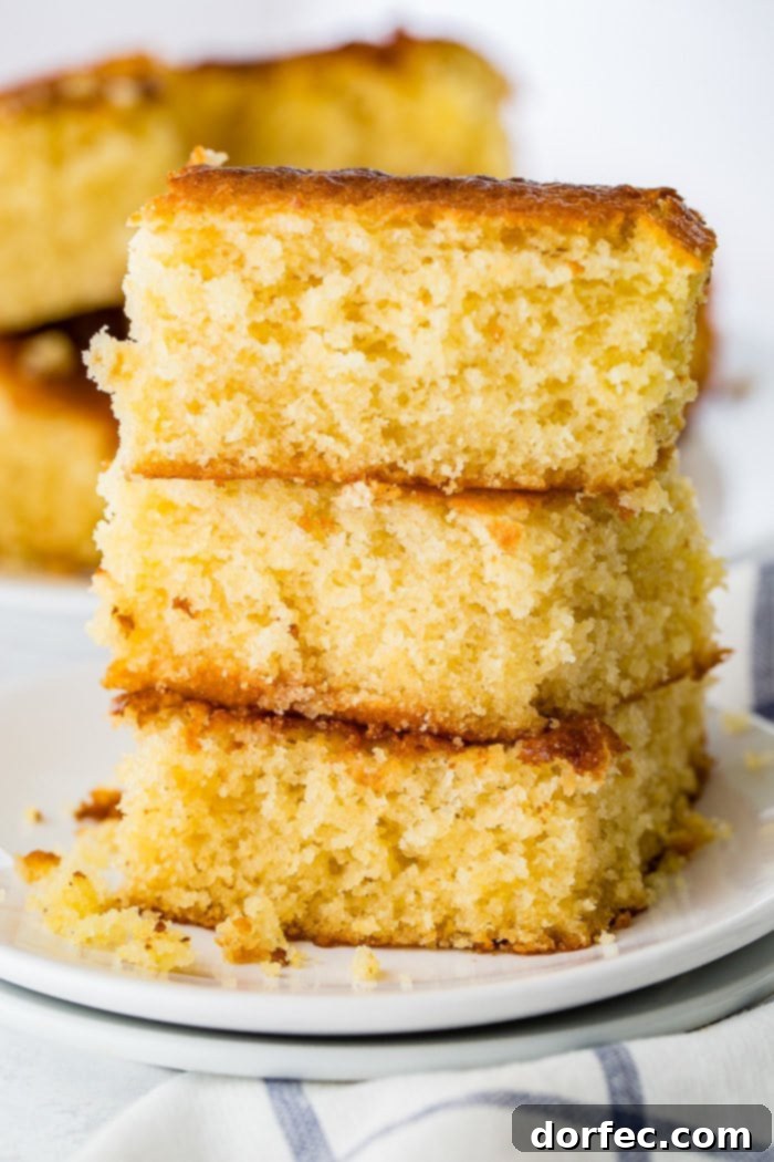 Three pieces of sweet, moist homemade cornbread stacked neatly on a plate.