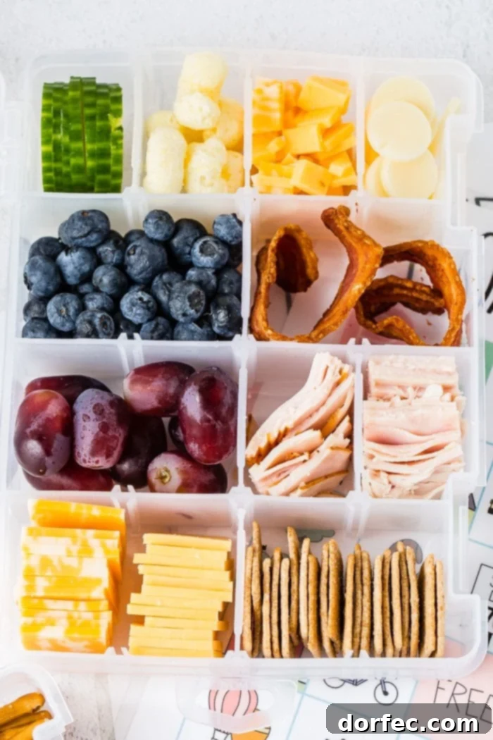 Road Trip Ready Smart Snacks and Fun Printables 2 A craft box typically used for beads or other crafts is cleverly repurposed and filled with an assortment of healthy snacks, including nuts, fresh fruits, mini sandwiches, cheese slices, and crackers, creating a wholesome road trip snack box.