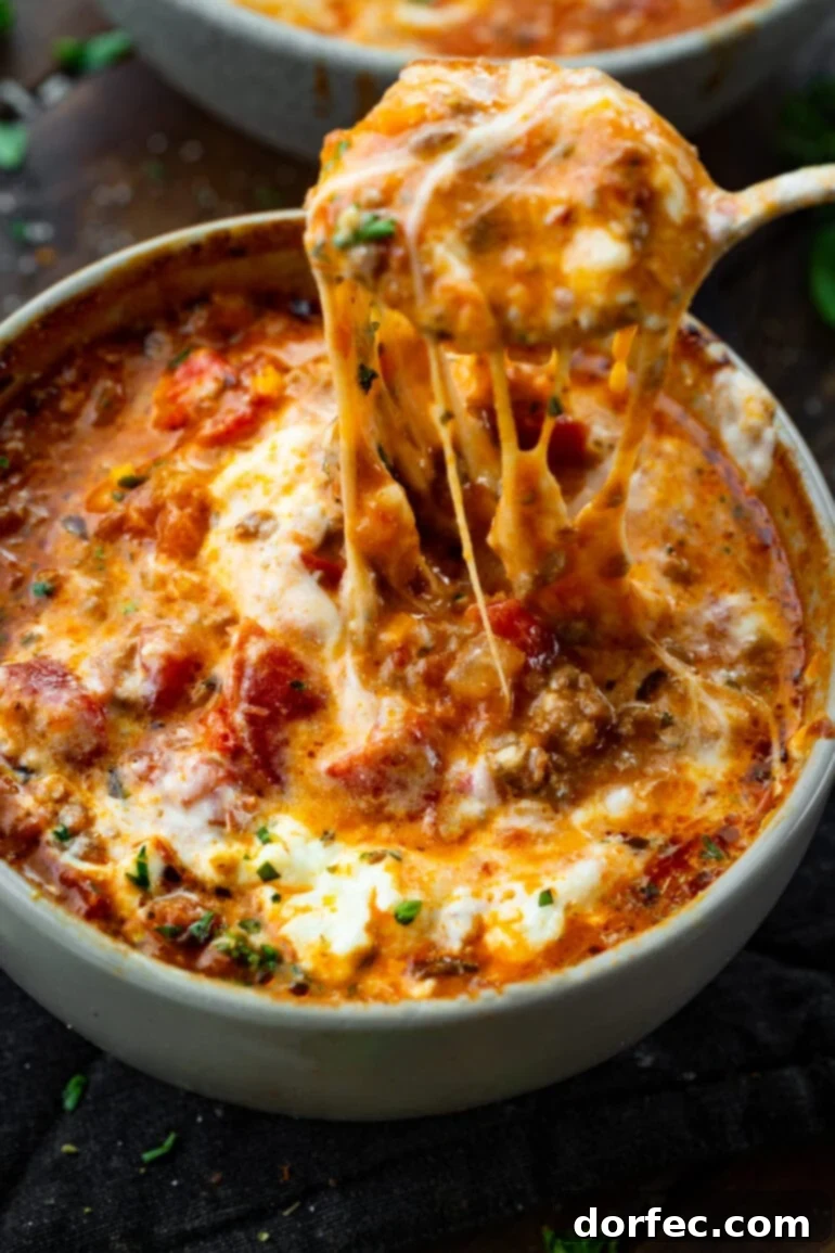 A Bowl of Lasagna Bliss 2 A steaming bowl of hearty lasagna soup, generously topped with melted mozzarella and ricotta cheese, with a spoon lifting a delicious string of cheese.