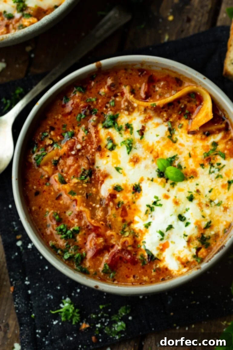 A Bowl of Lasagna Bliss 4 A vibrant bowl of hearty lasagna soup, garnished with fresh chopped herbs and bubbling melted cheese, ready to be enjoyed.