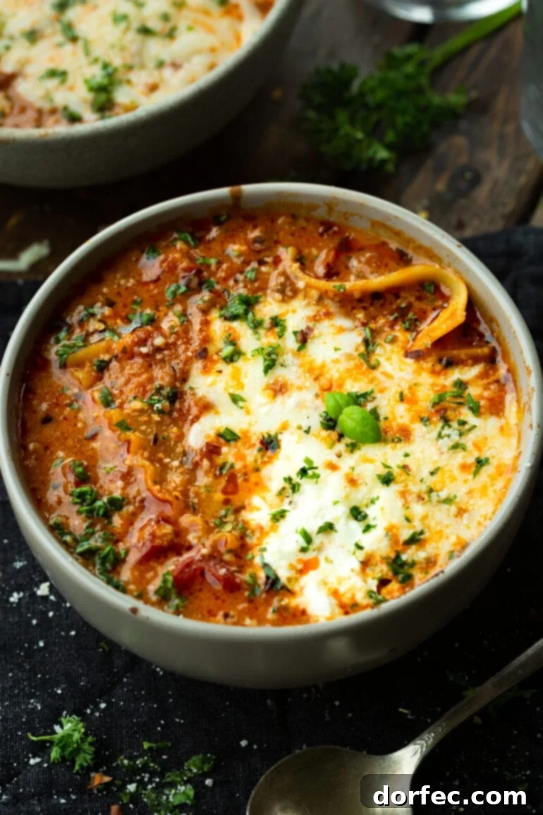 A Bowl of Lasagna Bliss 10 A large, inviting bowl of lasagna soup, generously topped with melted mozzarella cheese and a sprinkle of fresh green herbs, promising a comforting meal.