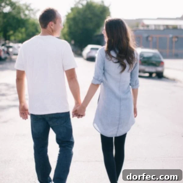 A photo of Cade and I holding hands, walking, and looking at each other taken from behind us, symbolizing partnership and shared journey.