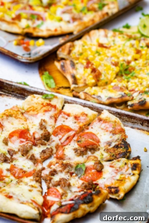 A photo of a pesto pepperoni grilled pizza with another grilled pizza topped in the corn in the background.