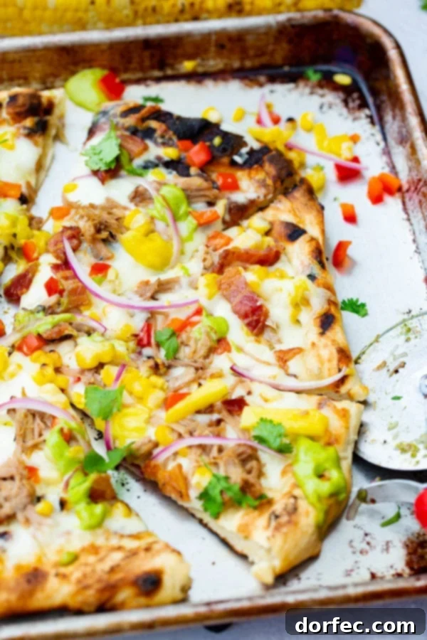 Pulled Pork Pizza with Sweet Corn and Cilantro Cream A photo of pulled pork pizza covered in sweet corn, red onions, pinapple, bacon, and fresh cilantro.