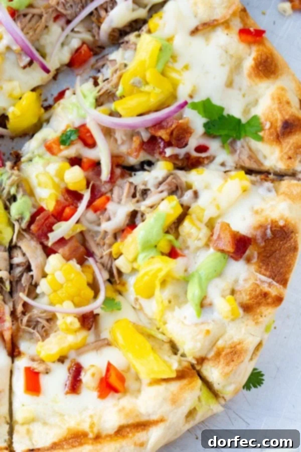 Pulled Pork Pizza with Sweet Corn and Cilantro Cream A photo of pulled pork pizza covered in sweet corn, red onions, pinapple, bacon, and fresh cilantro.