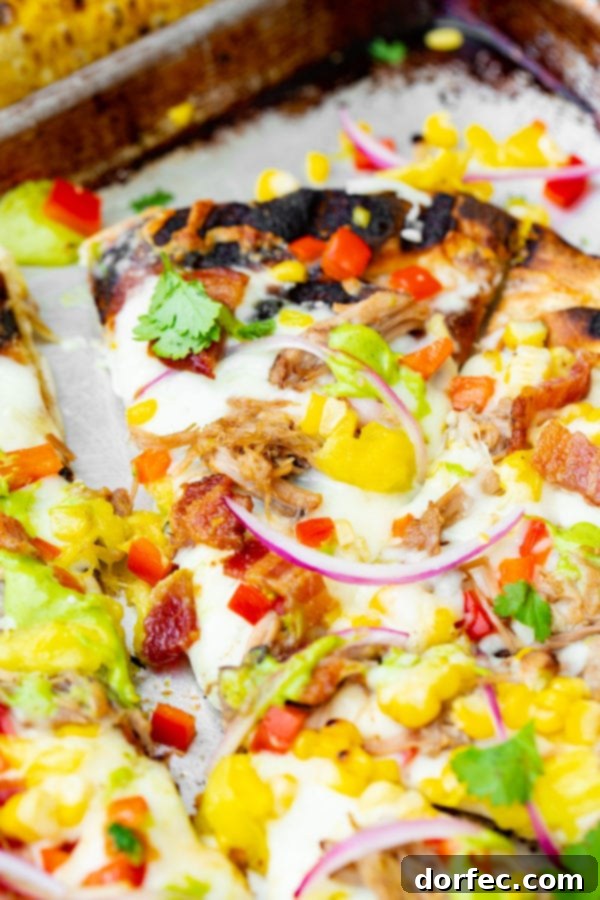 Pulled Pork Pizza with Sweet Corn and Cilantro Cream A photo of pulled pork pizza covered in sweet corn, red onions, pinapple, bacon, and fresh cilantro.