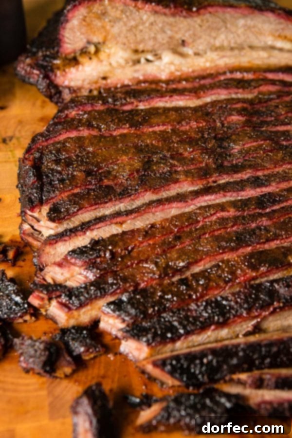 A photo of perfectly smoked brisket sliced on a wooden cutting board.