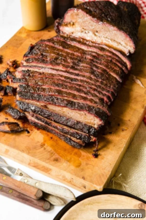 A photo of perfectly smoked brisket sliced on a wooden cutting board.