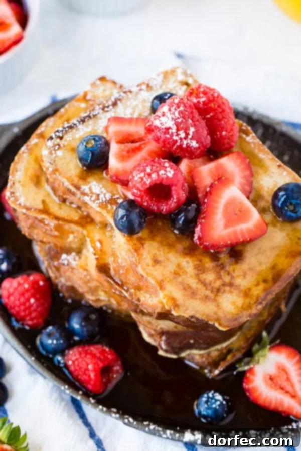 Delicious French Toast Breakfast A photo of a stack of perfectly cooked French toast covered in dripping syrup and fresh berries, ready for a delicious breakfast.