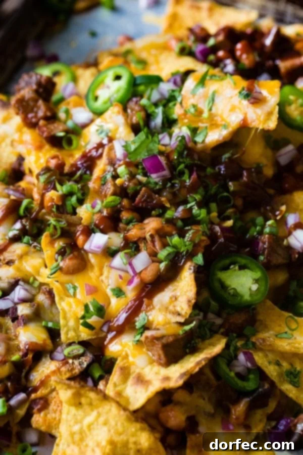 A close-up photo of gooey, cheesy BBQ brisket nachos, adorned with vibrant toppings like sliced jalapenos, diced red onion, and fresh cilantro, highlighting the rich textures.