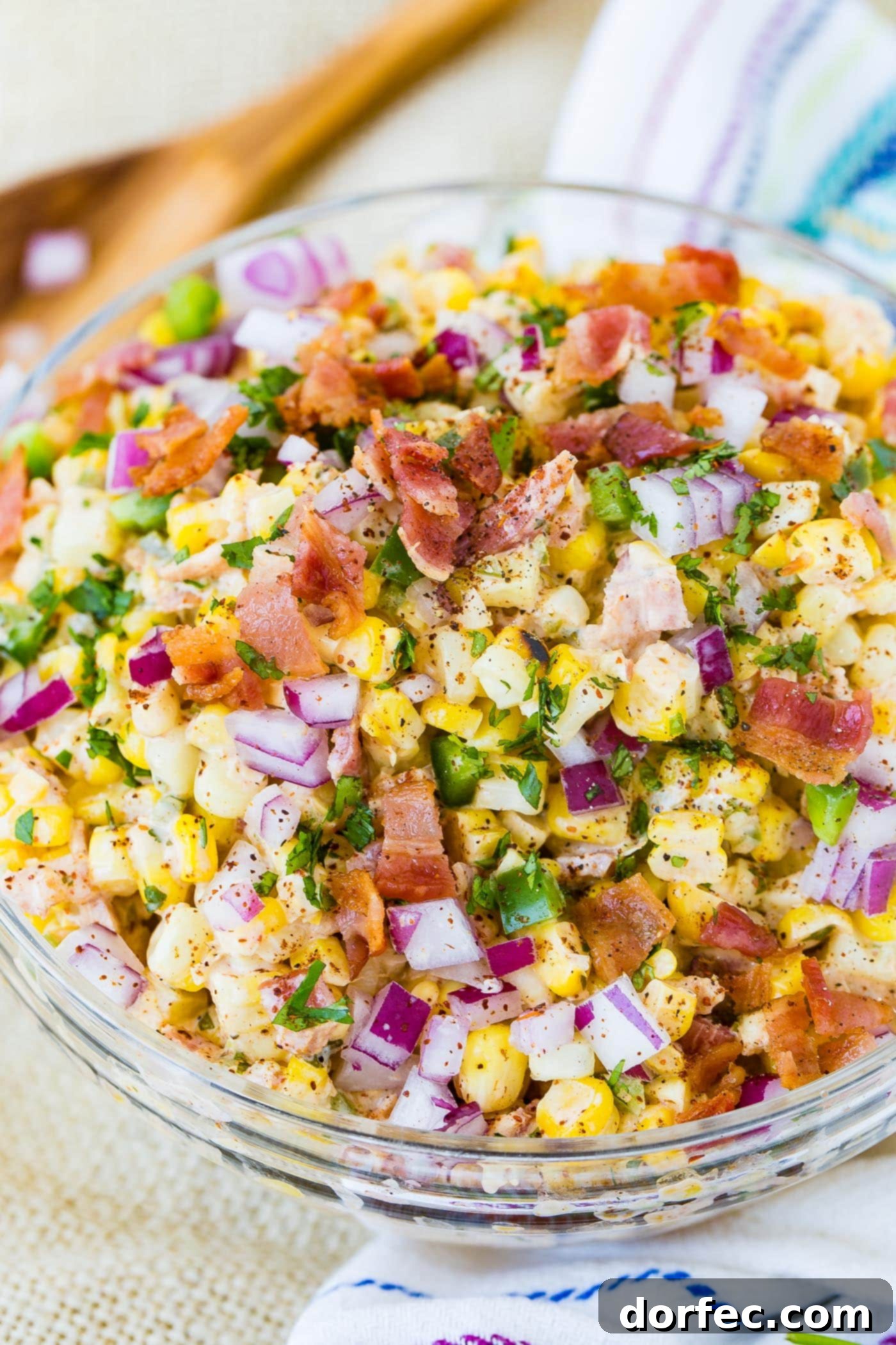 A bowl of Mexican corn salad topped with bacon and jalapeno.
