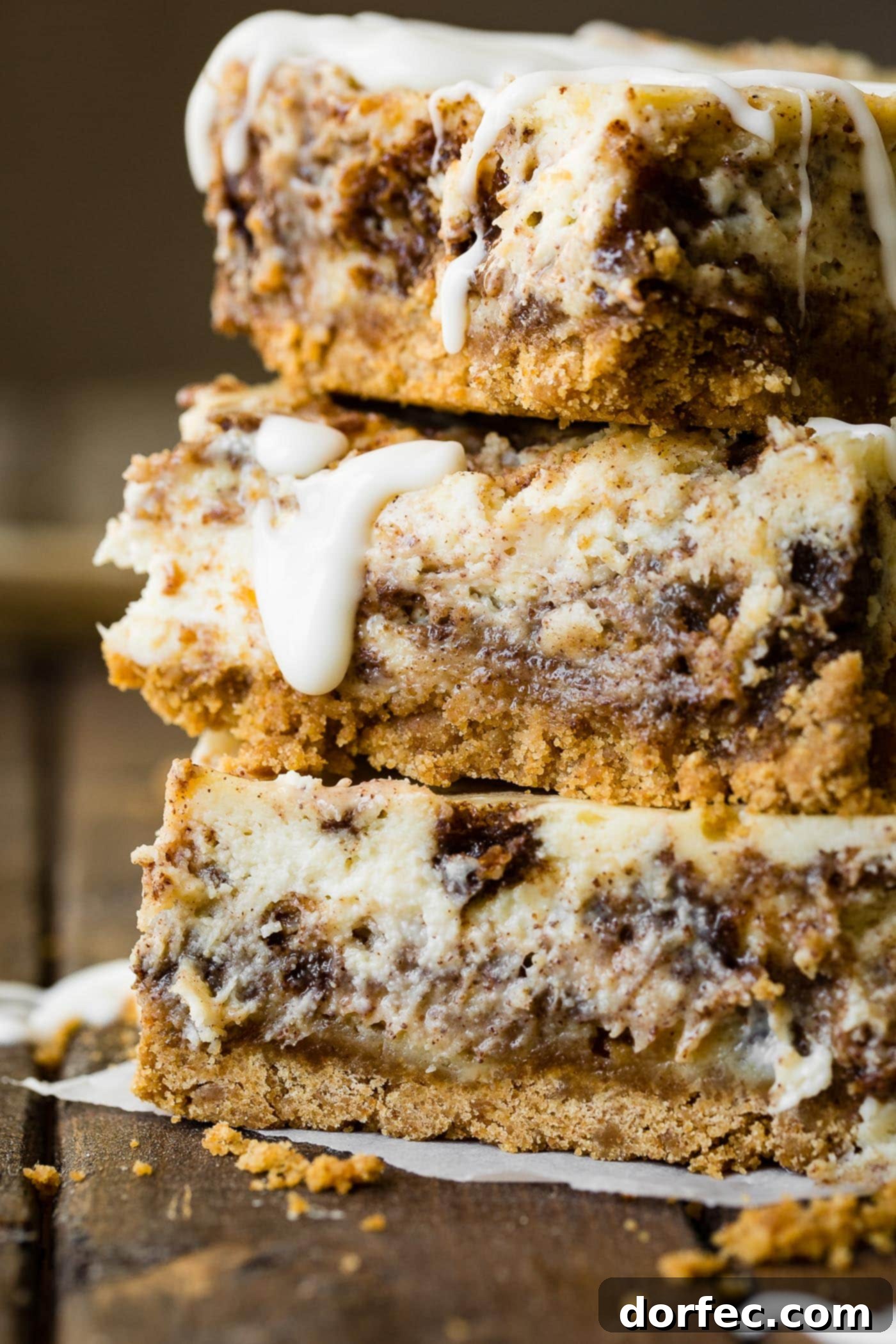 A final photo of three cinnamon roll cheesecake bars, showcasing their irresistible appeal.