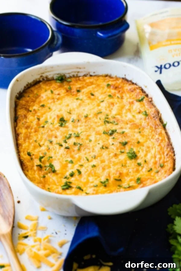 A white ceramic baking dish generously filled with golden-brown Jiffy corn casserole, ready to be served.