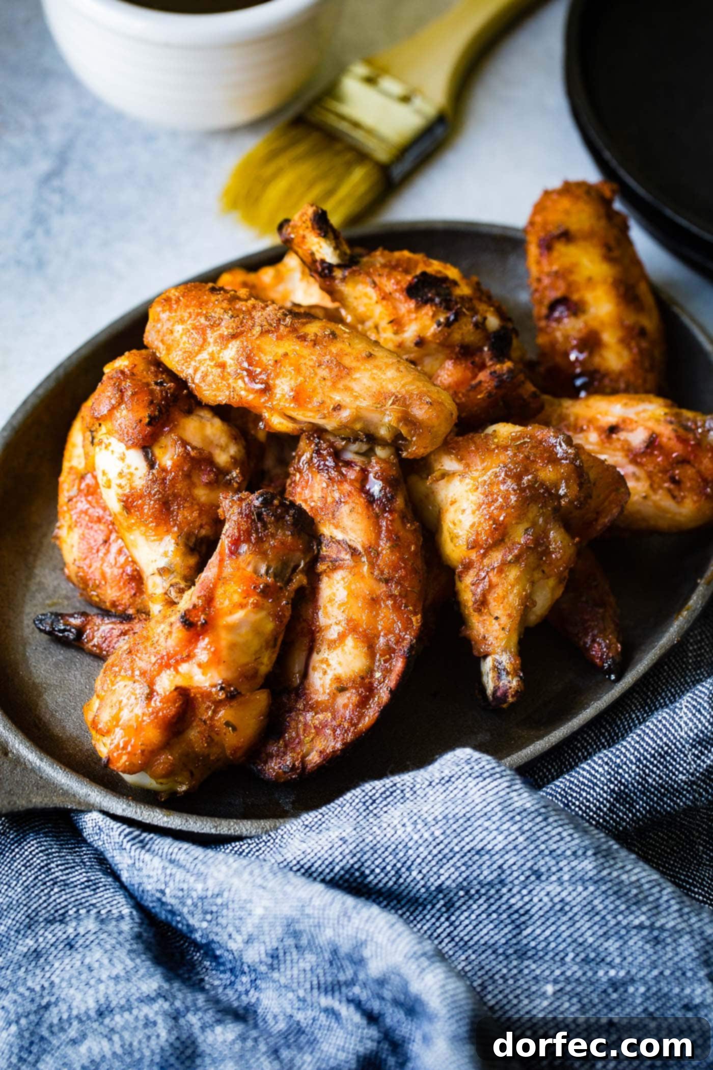The BEST Dry Rubbed Smoked Chicken Wings An appetizing overhead shot of a platter filled with perfectly dry-rubbed smoked chicken wings, highlighting their crispy texture and rich color.