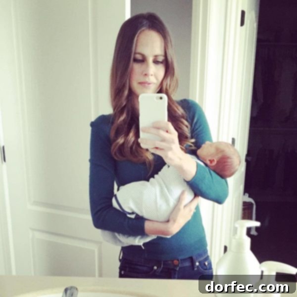 A photo of me in the mirror holding our new baby at home, reflecting on the past and present.