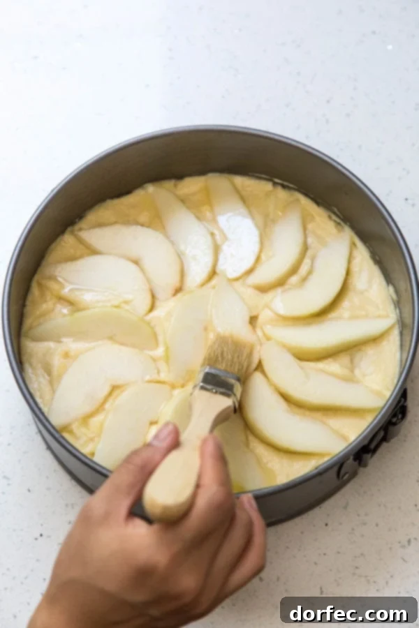 Brushing pears with butter before baking, showing attention to detail