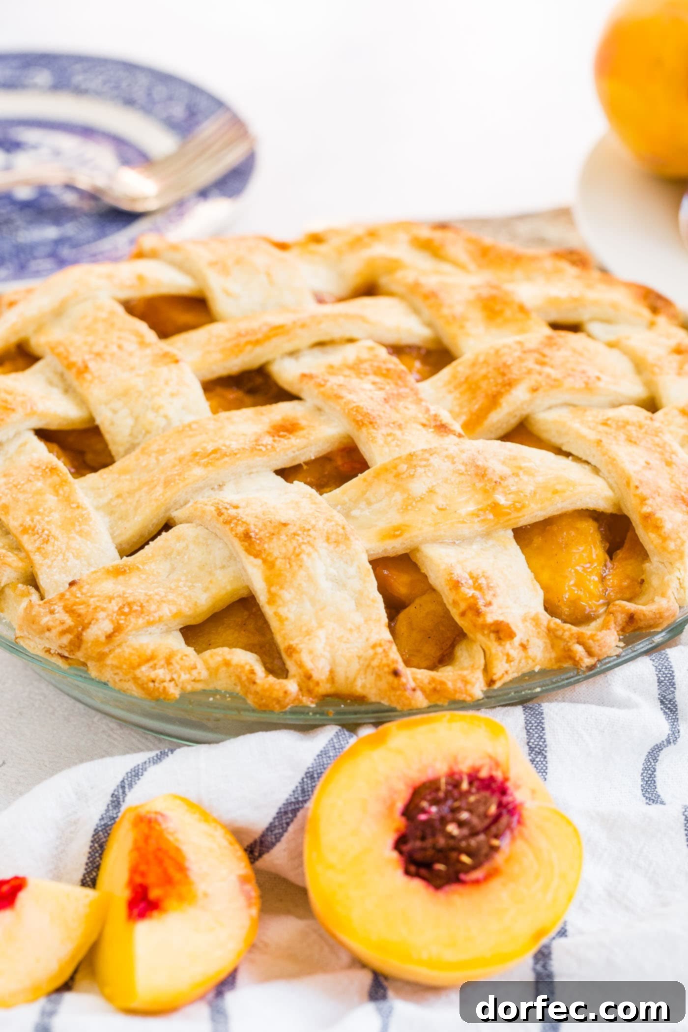 A photo of a fresh peach pie with a beautiful golden lattice crust.