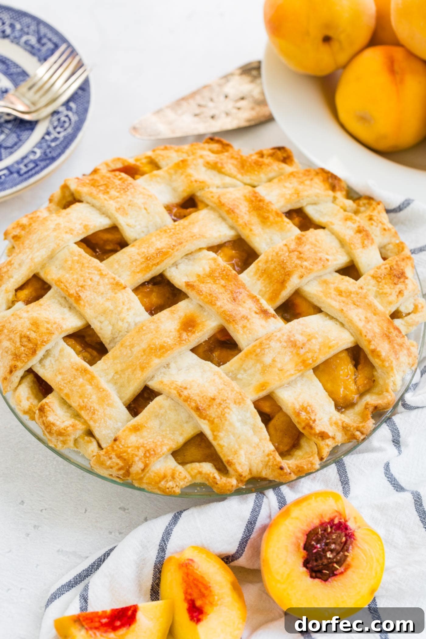 A photo of a fresh peach pie with a beautiful golden lattice crust.