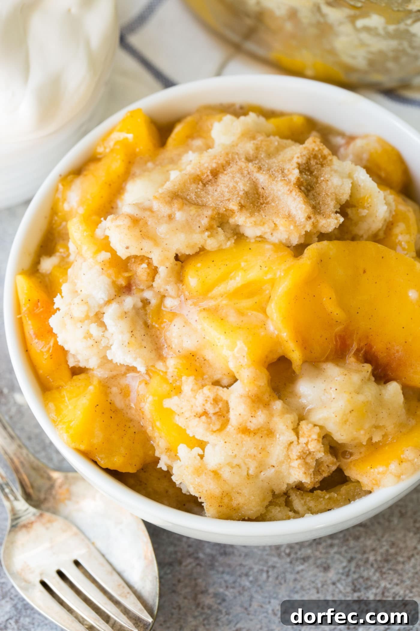 Easy Instant Pot Peach Cobbler with Cake Mix A close-up of a spoon scooping Instant Pot peach cobbler, revealing the sweet peach filling and moist cake topping.