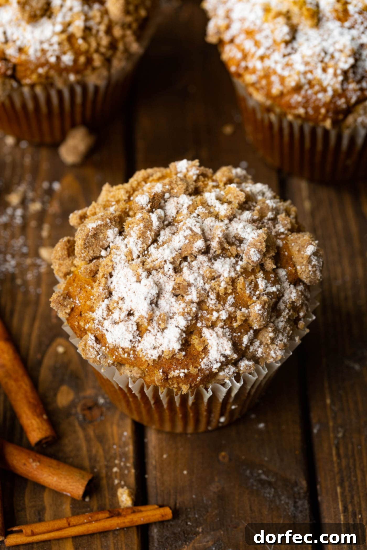 A close-up of a freshly baked jumbo pumpkin streusel muffin, showcasing its golden-brown top and crumbly streusel.