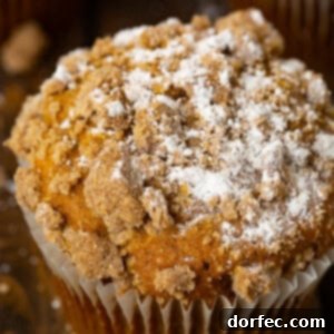 A delicious jumbo pumpkin streusel muffin, artfully garnished with a dusting of powdered sugar.
