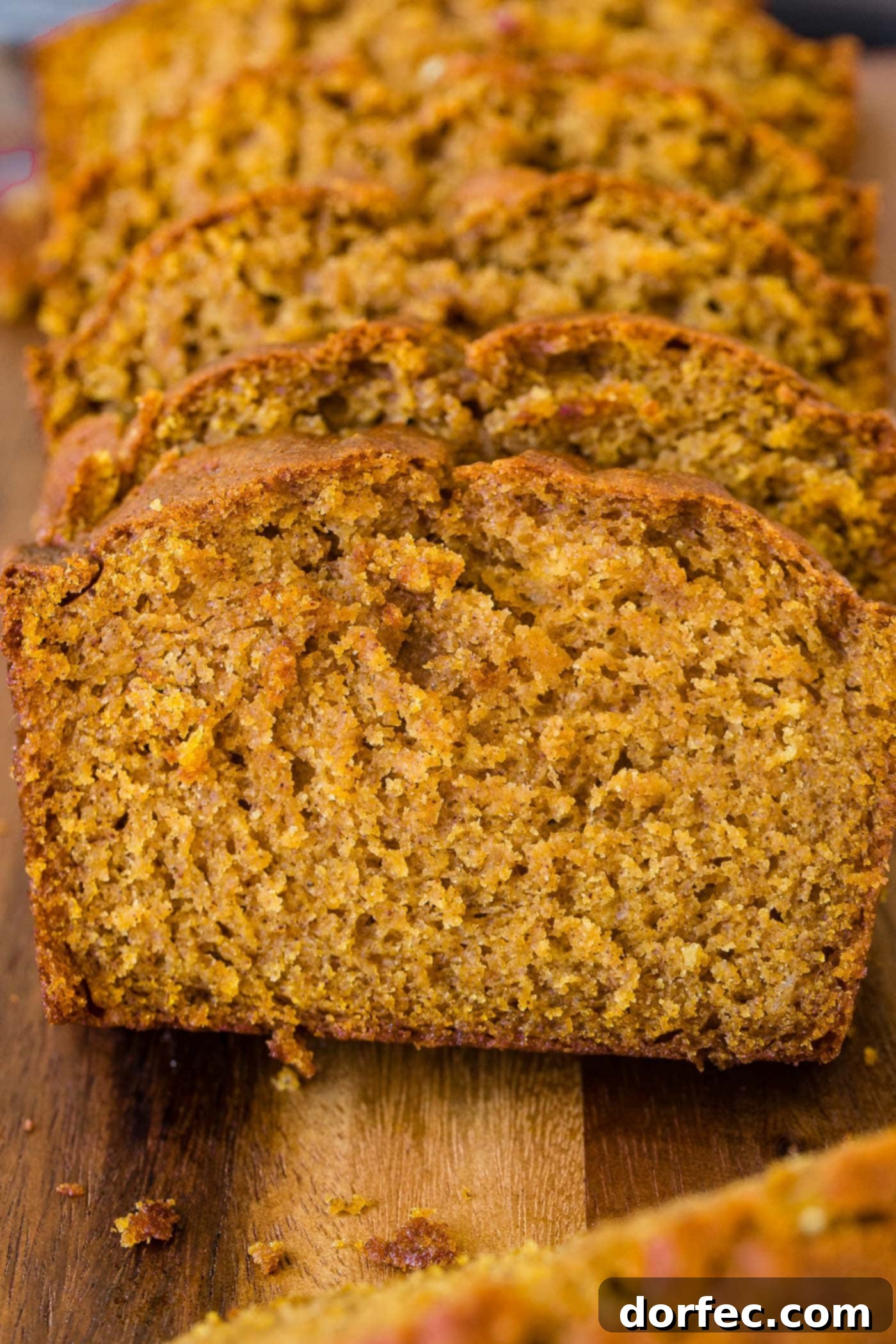 Delicious Pumpkin Bread A thick slice of warm, inviting pumpkin bread, showcasing its perfectly moist crumb and rich color.