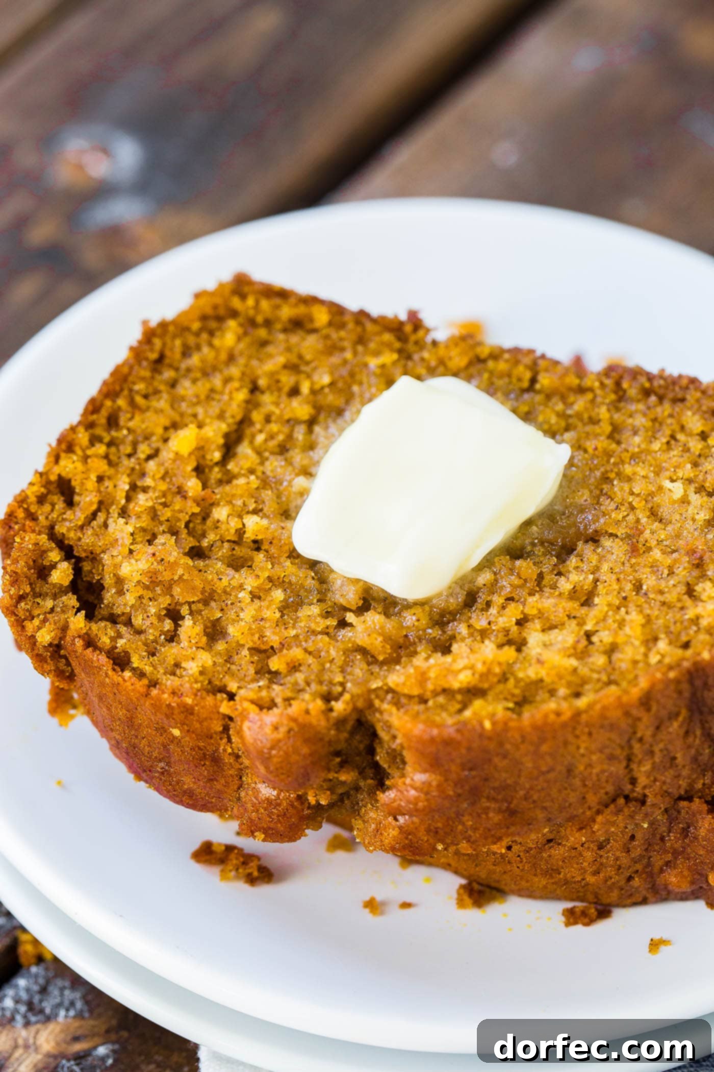 Best Ever Pumpkin Bread A glorious loaf of pumpkin bread, expertly sliced and arranged on a wooden board, inviting you to take a piece.