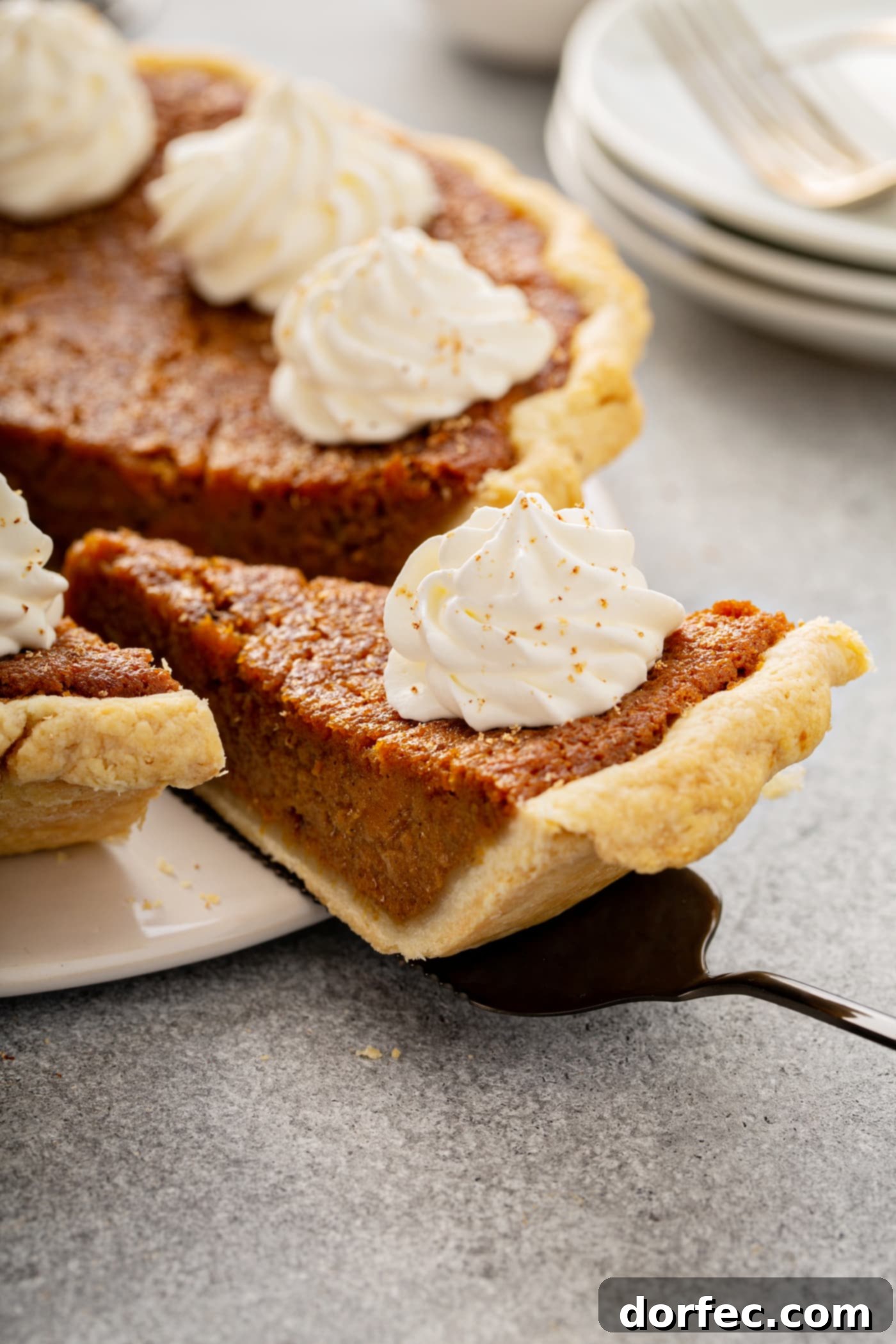 Southern Charm Sweet Potato Pie 14 A photo of a slice of sweet potato pie being removed from a whole pie.
