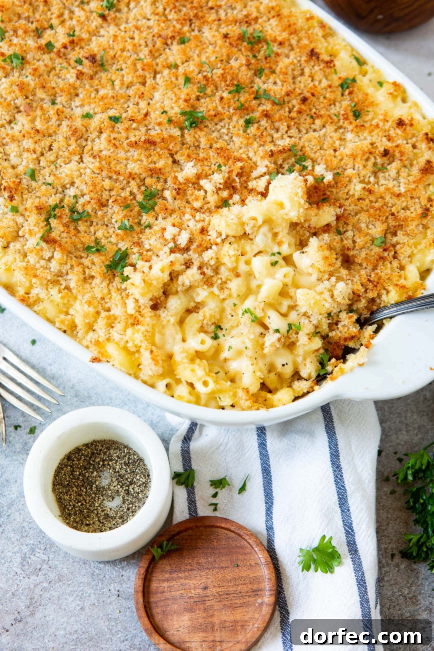 Best Macaroni and Cheese Ever Baked Macaroni and cheese in a casserole dish. There is a fork and a container of pepper next to the dish.