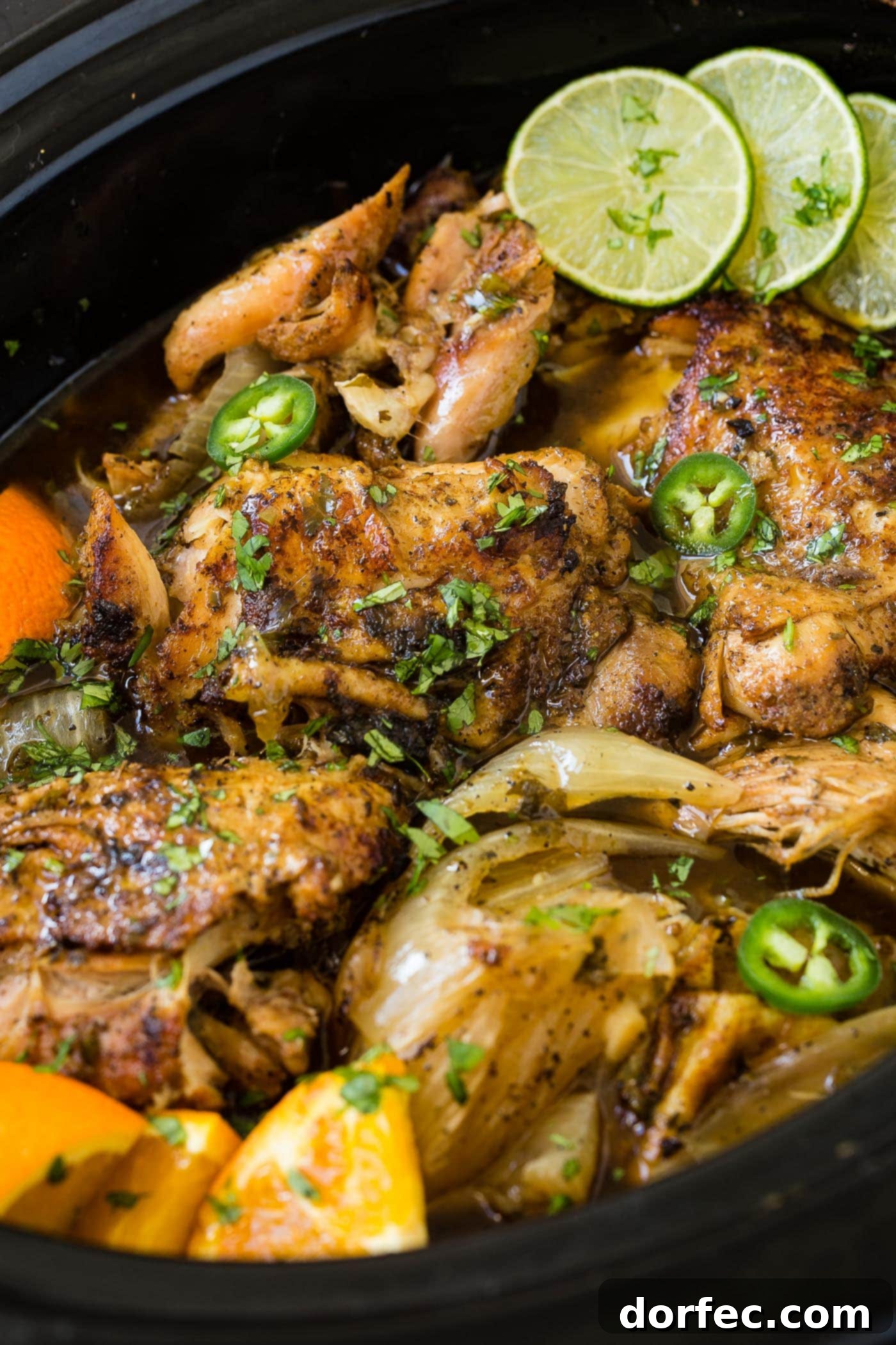 A photo of chicken carnitas being cooked in a slow cooker.