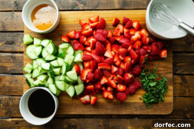 Honey Balsamic Strawberry Cucumber Salad 4 A flat lay photo showing all the fresh ingredients for strawberry cucumber salad laid out on a rustic wooden cutting board.