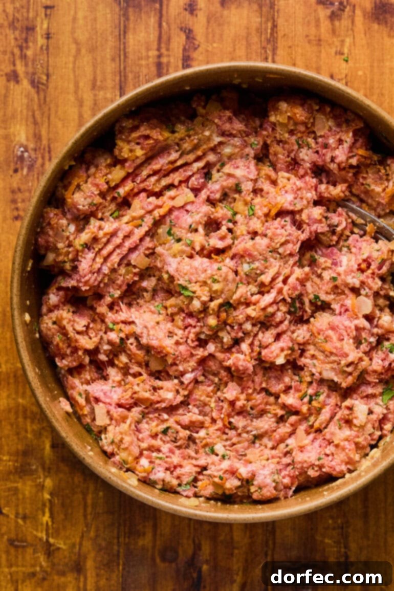 Meatloaf mixture pressed firmly into a loaf pan, ready for its first glaze application.
