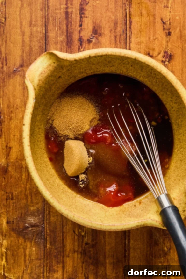 A bowl with the egg mixture now combined with Dijon mustard, ketchup, and Worcestershire sauce, ready for the meat.