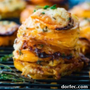Golden Gruyere Sweet Potato Stacks 2 A photo of a stack of thinly sliced sweet potatoes layered with gruyere and parmesan cheese and topped with fresh thyme.