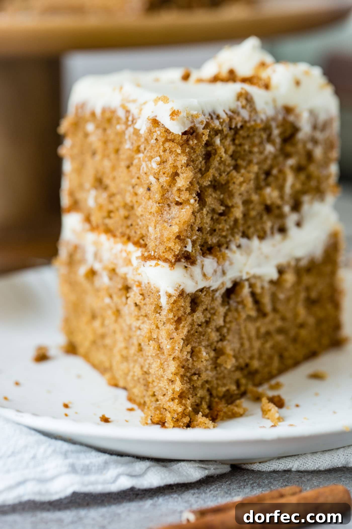 Layers of Spice Cake A slice of two-layer spice cake, showcasing the moist cake layers and generous cream cheese frosting between and on top.