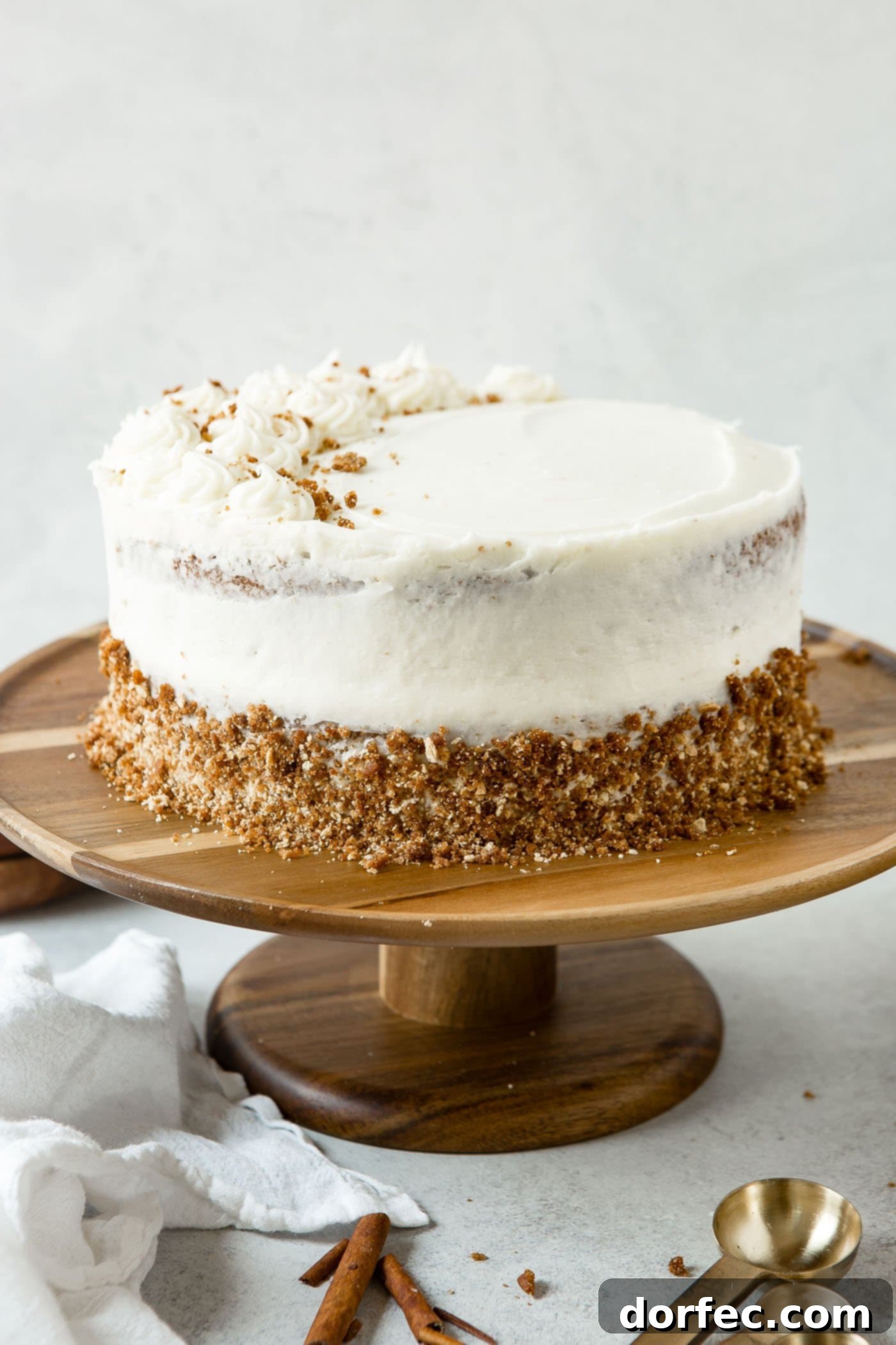 Whole Spice Cake on Display A fully assembled two-layer spice cake, frosted with cream cheese, sitting on a rustic cake plate, ready to be served.