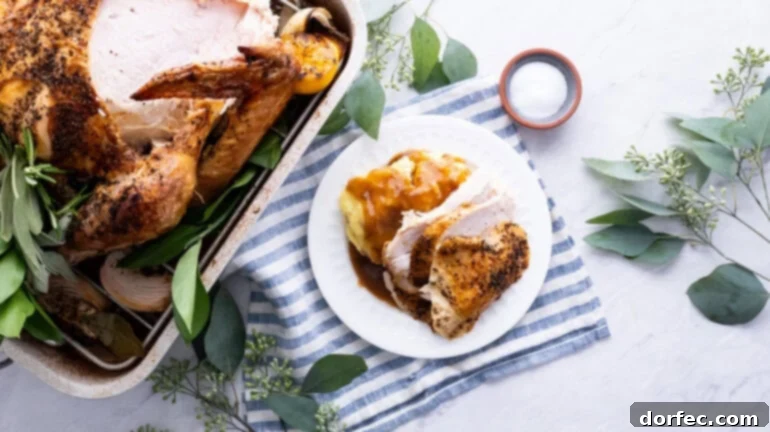 A photo of a whole roasted turkey with one breast expertly carved and placed on a plate next to the roasting pan, highlighting its juicy interior.