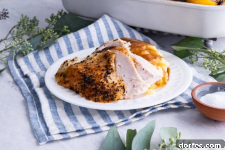 A photo of a large white platter topped with beautifully carved, juicy roasted turkey pieces, ready for serving.